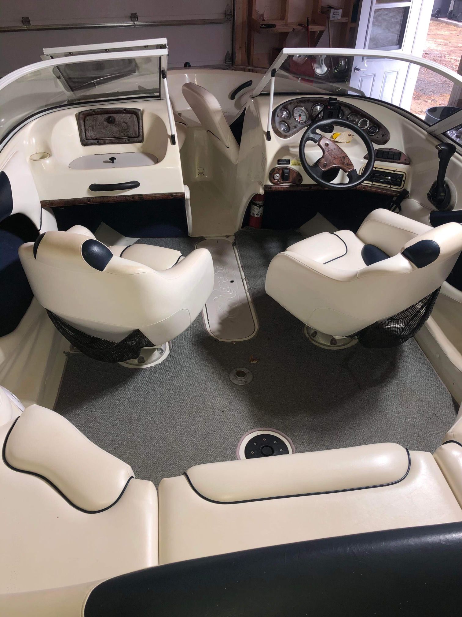 Intérieur d'un bateau avec des sièges blancs et un volant.