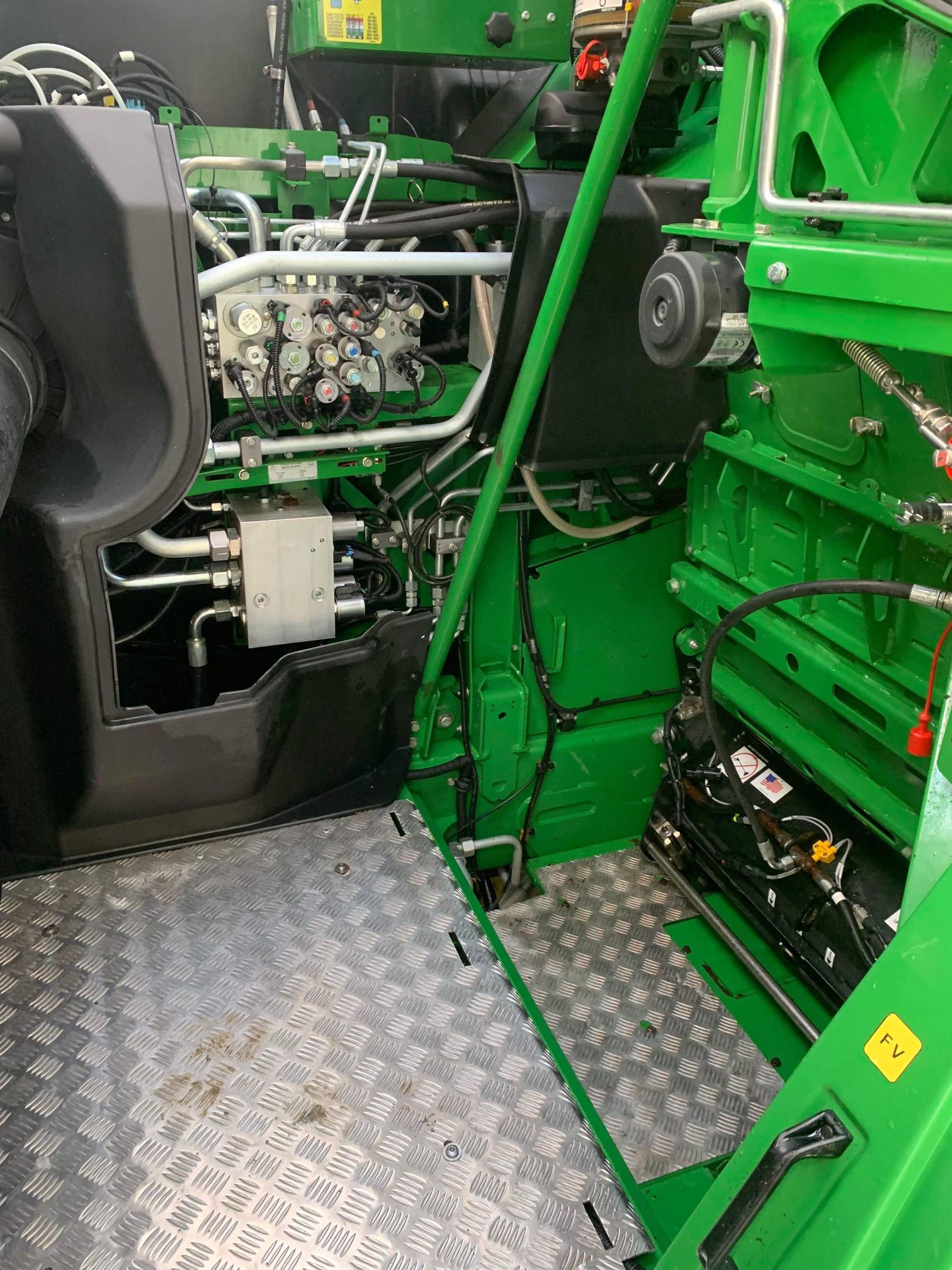 L'intérieur d'un tracteur vert avec le moteur visible.