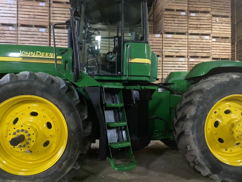 Un tracteur John Deere est garé dans un entrepôt