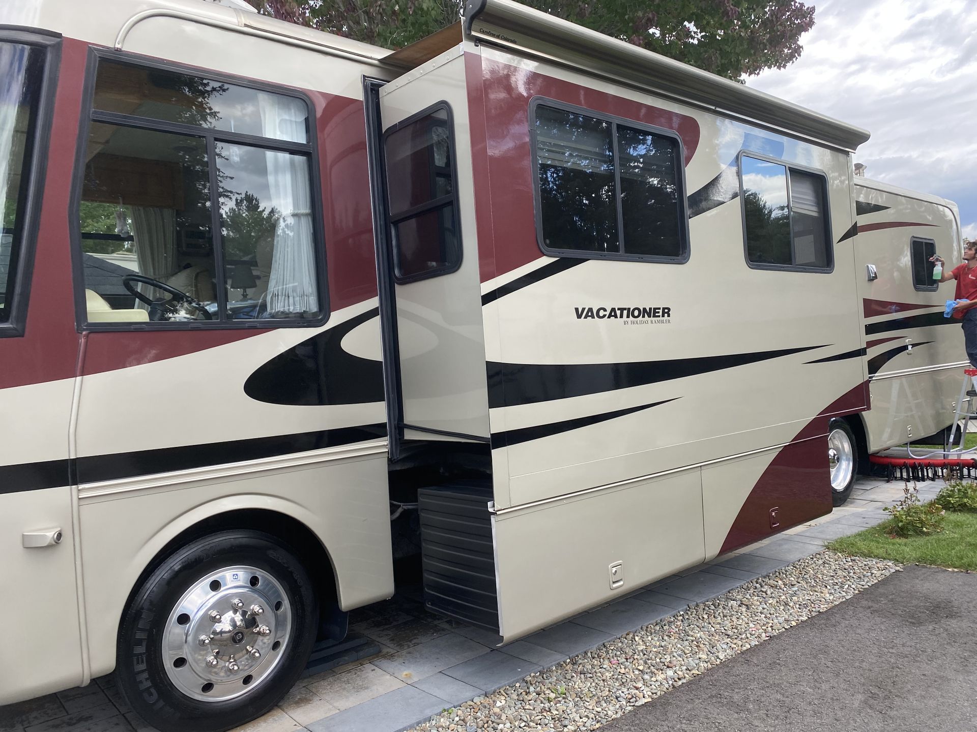 Un camping-car rouge et blanc est garé sur le bord de la route.
