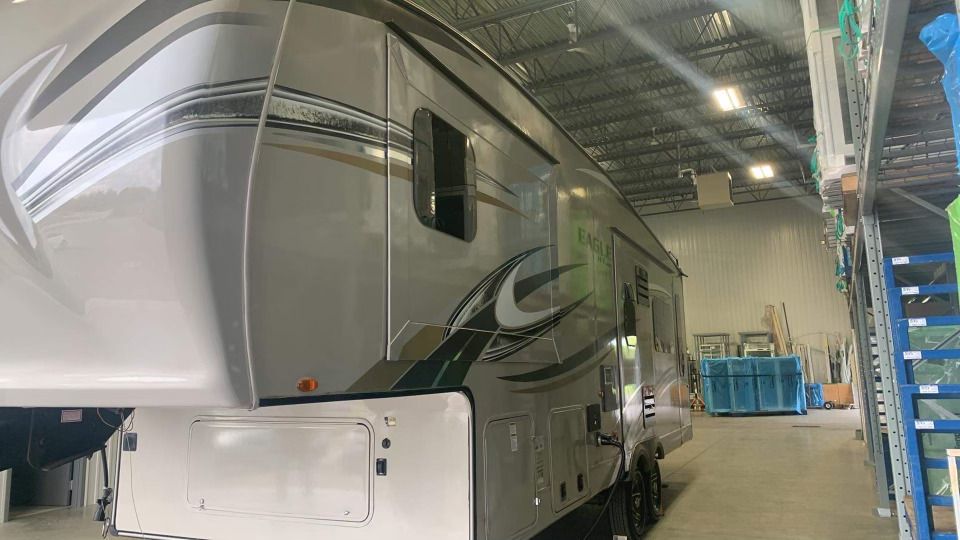 Un camping-car blanc est garé dans un grand entrepôt.