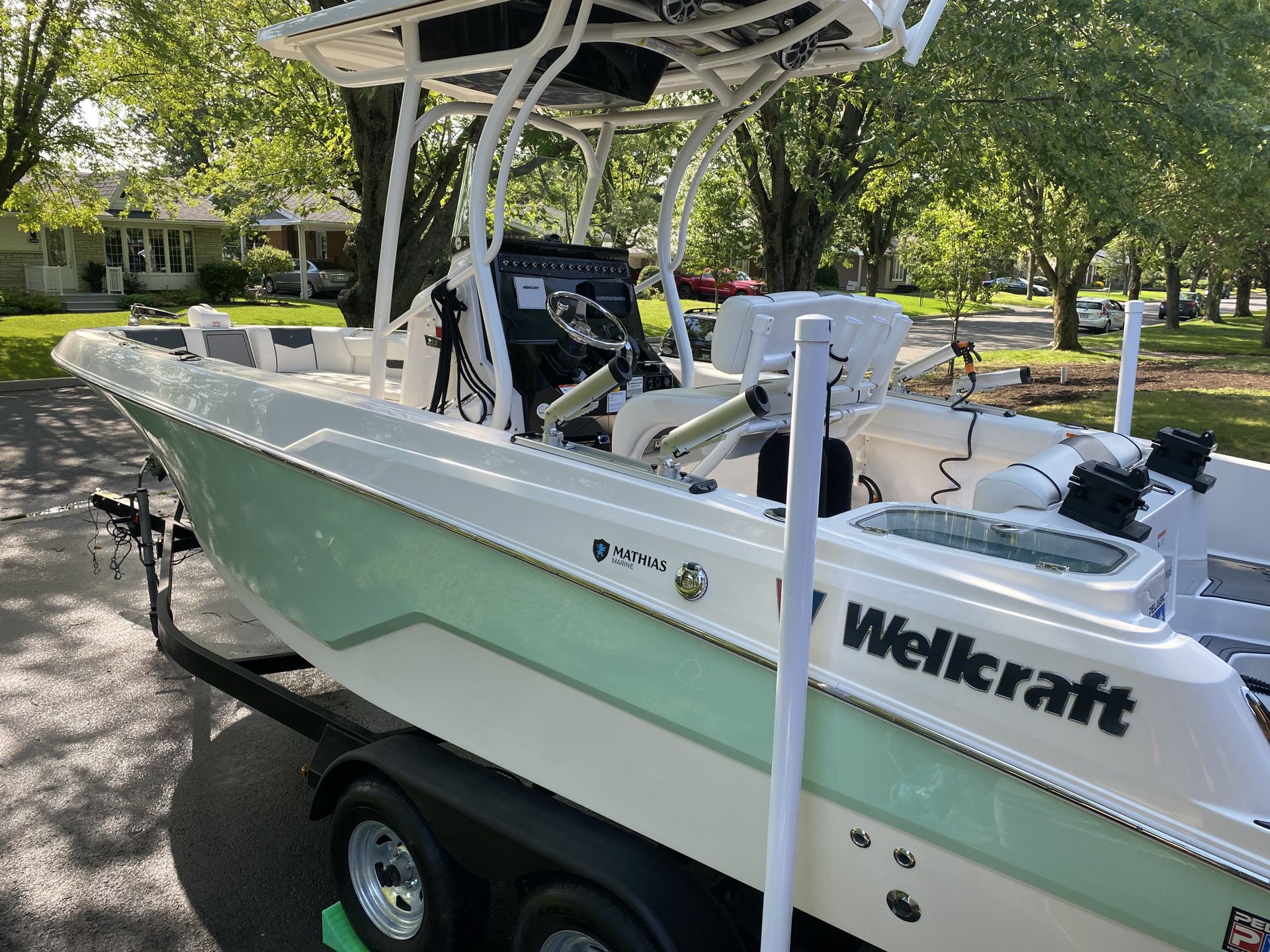 Un bateau Wellcraft est garé sur une remorque dans une allée.