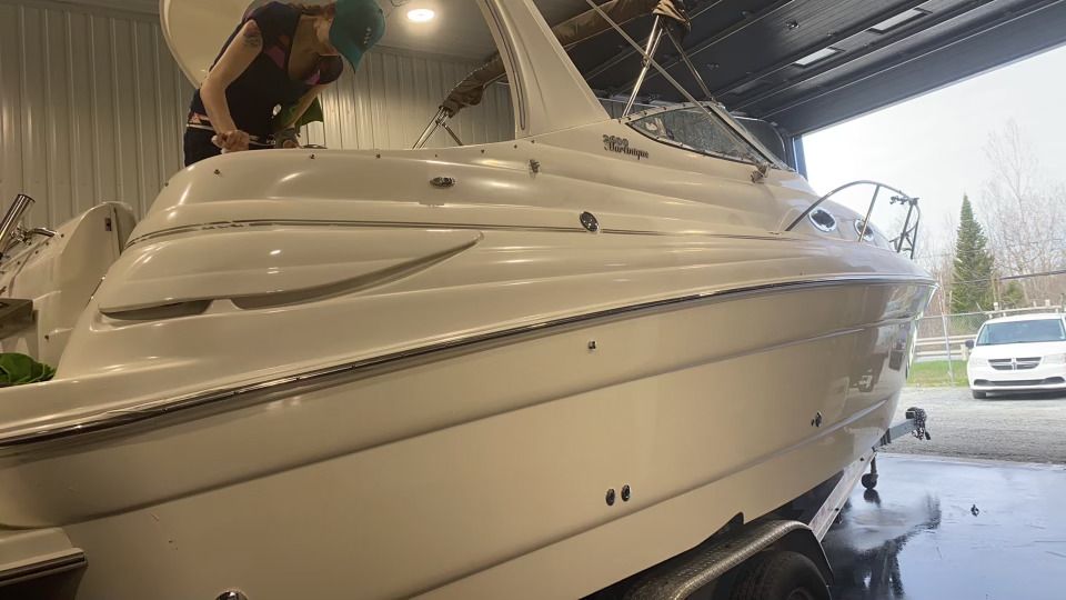 Une femme travaille sur un bateau dans un garage.