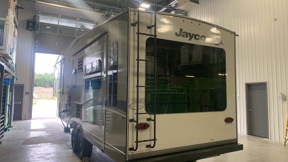 Un camping-car est garé dans un garage à côté d'un immeuble.