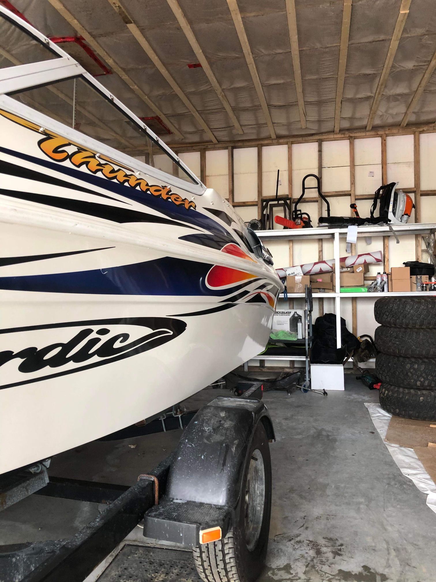 Un bateau est posé sur une remorque dans un garage.