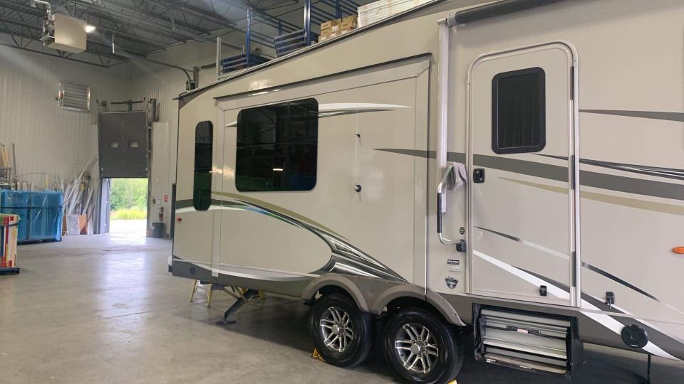Un camping-car blanc est garé dans un garage.