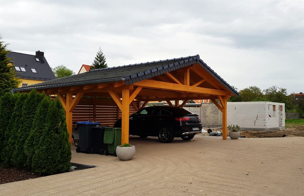 A Car Is Parked Under A Wooden Carport In A Driveway — Brad Griffiths Building In Culburra Beach, NSW