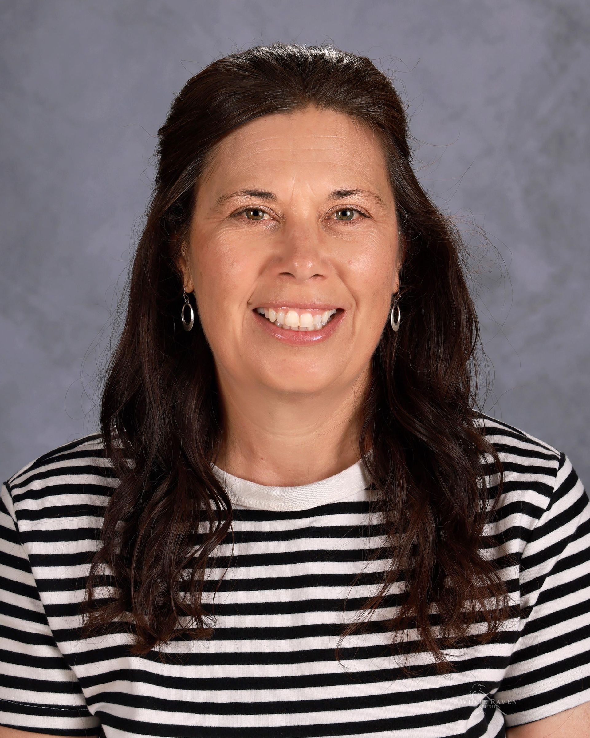Woman in striped shirt smiling at camera.