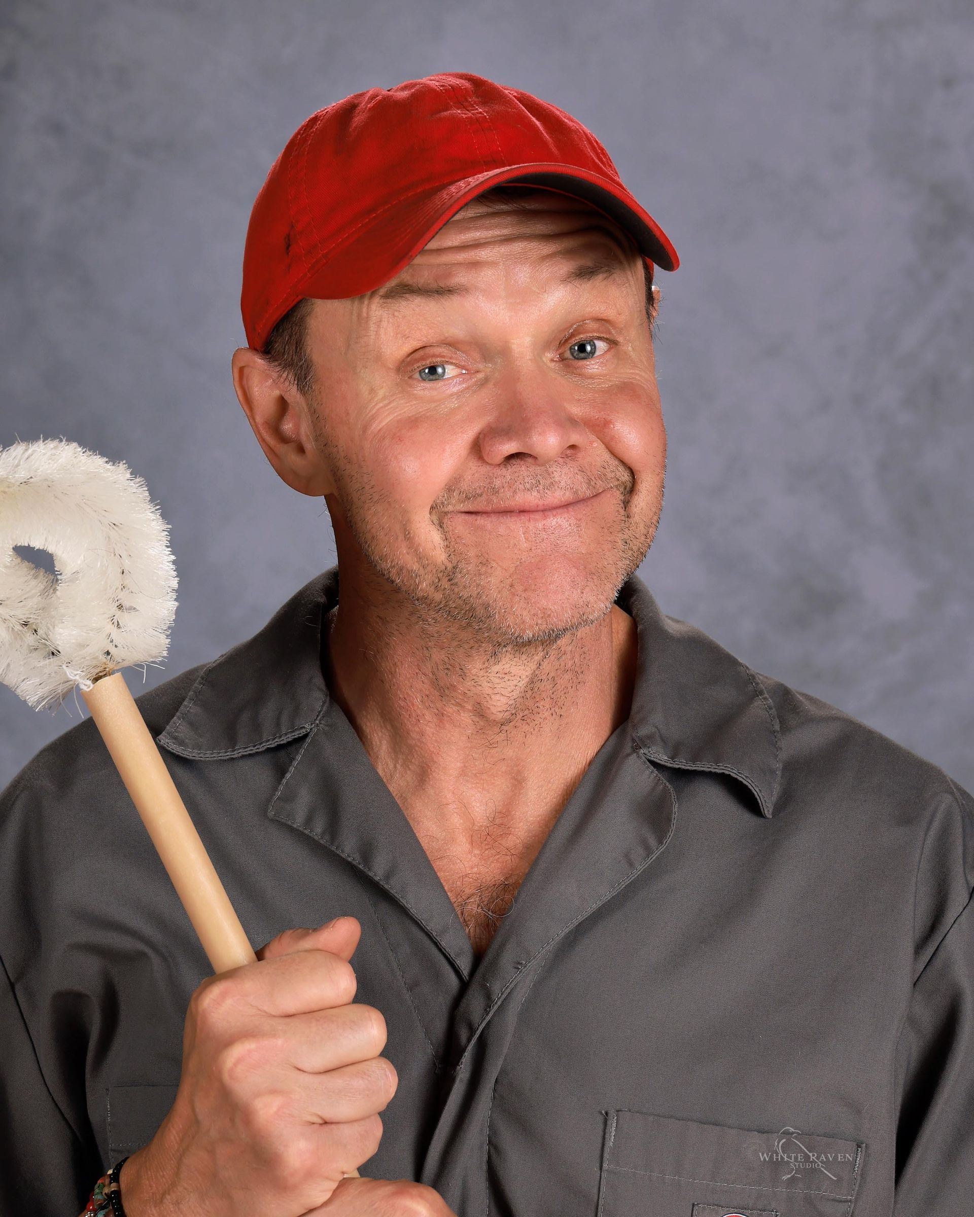 Man in white hat smiling at camera.