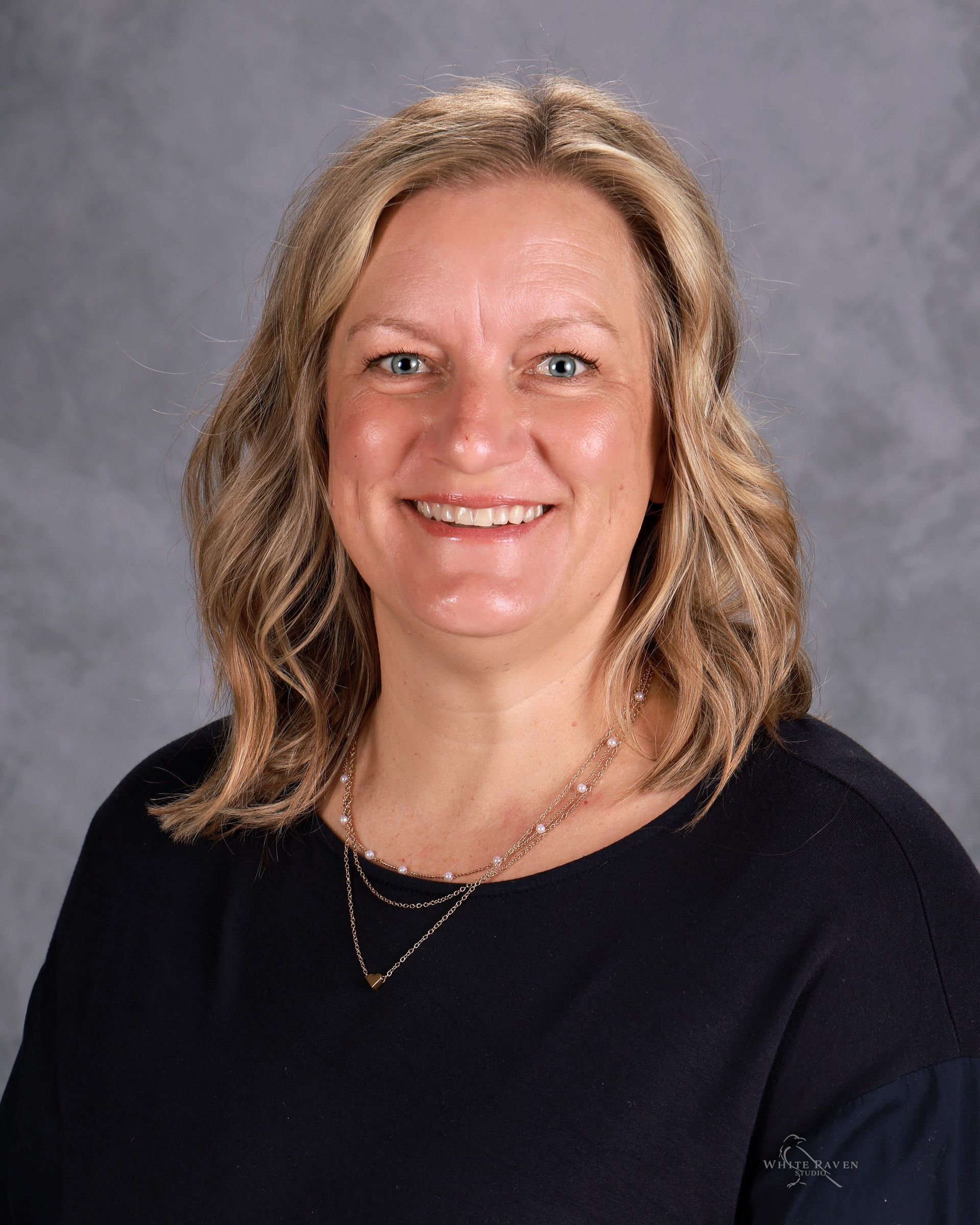 Woman with blonde hair smiling at camera.
