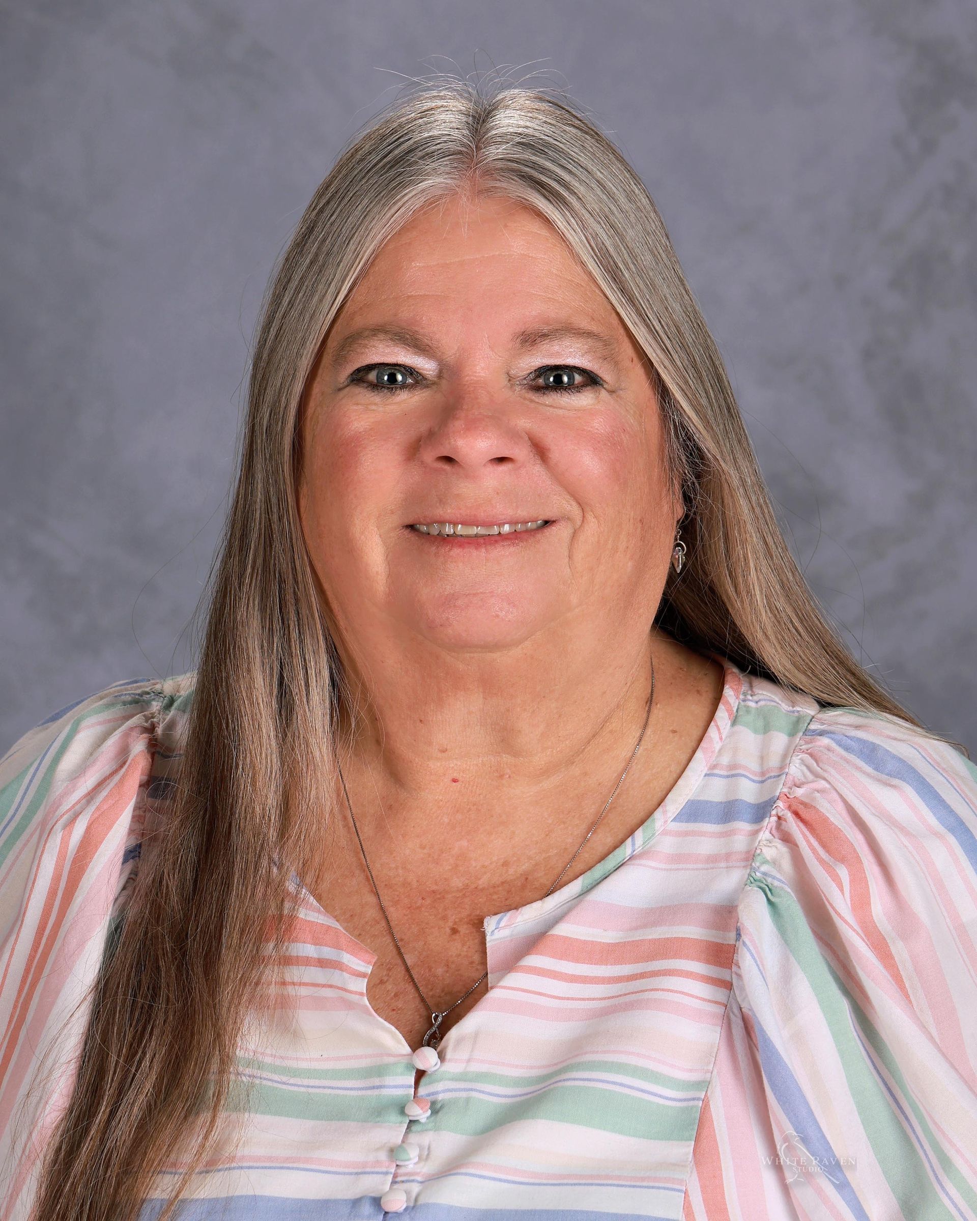 Woman in pink shirt smiling for camera.