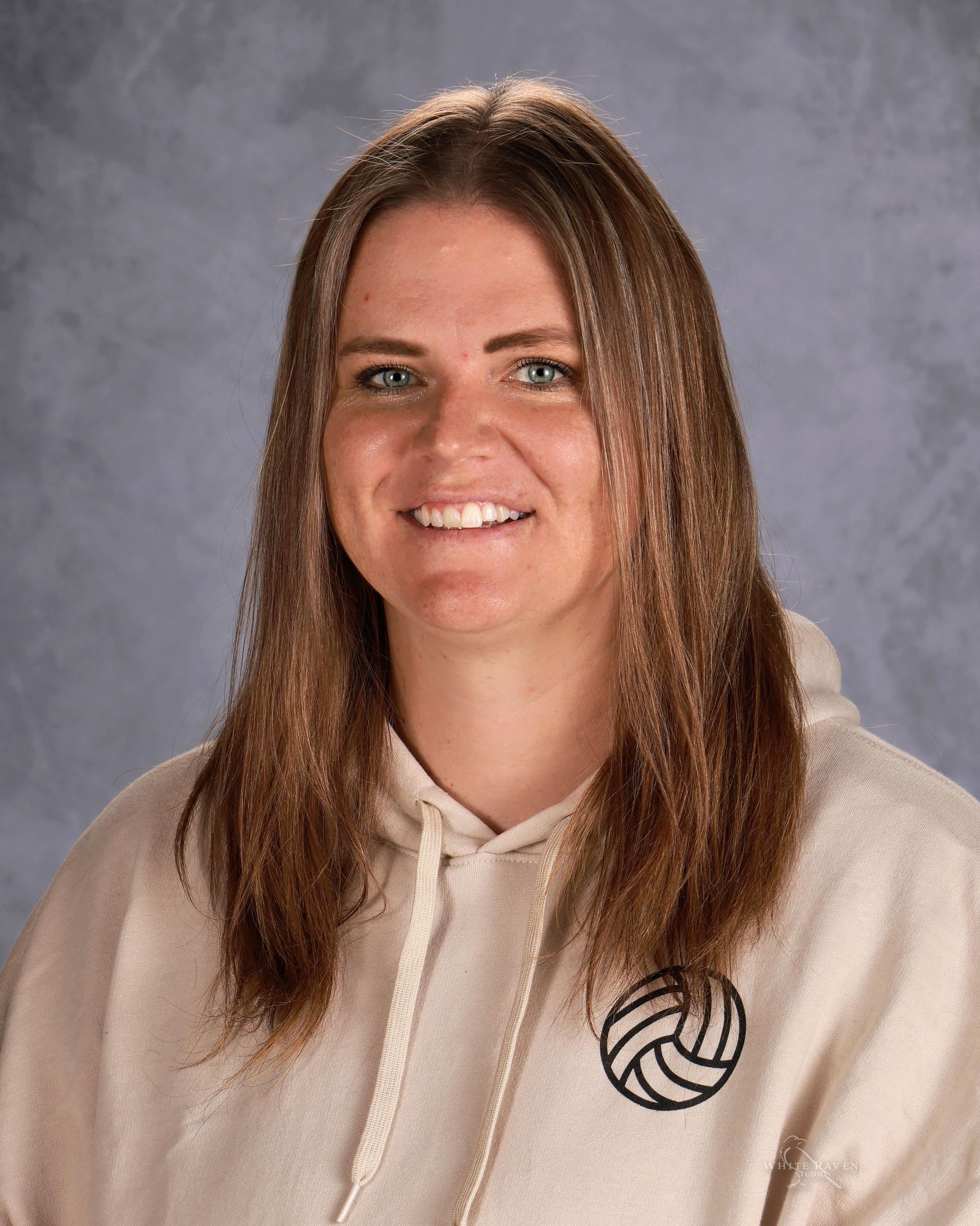 Woman in tan shirt smiling at camera