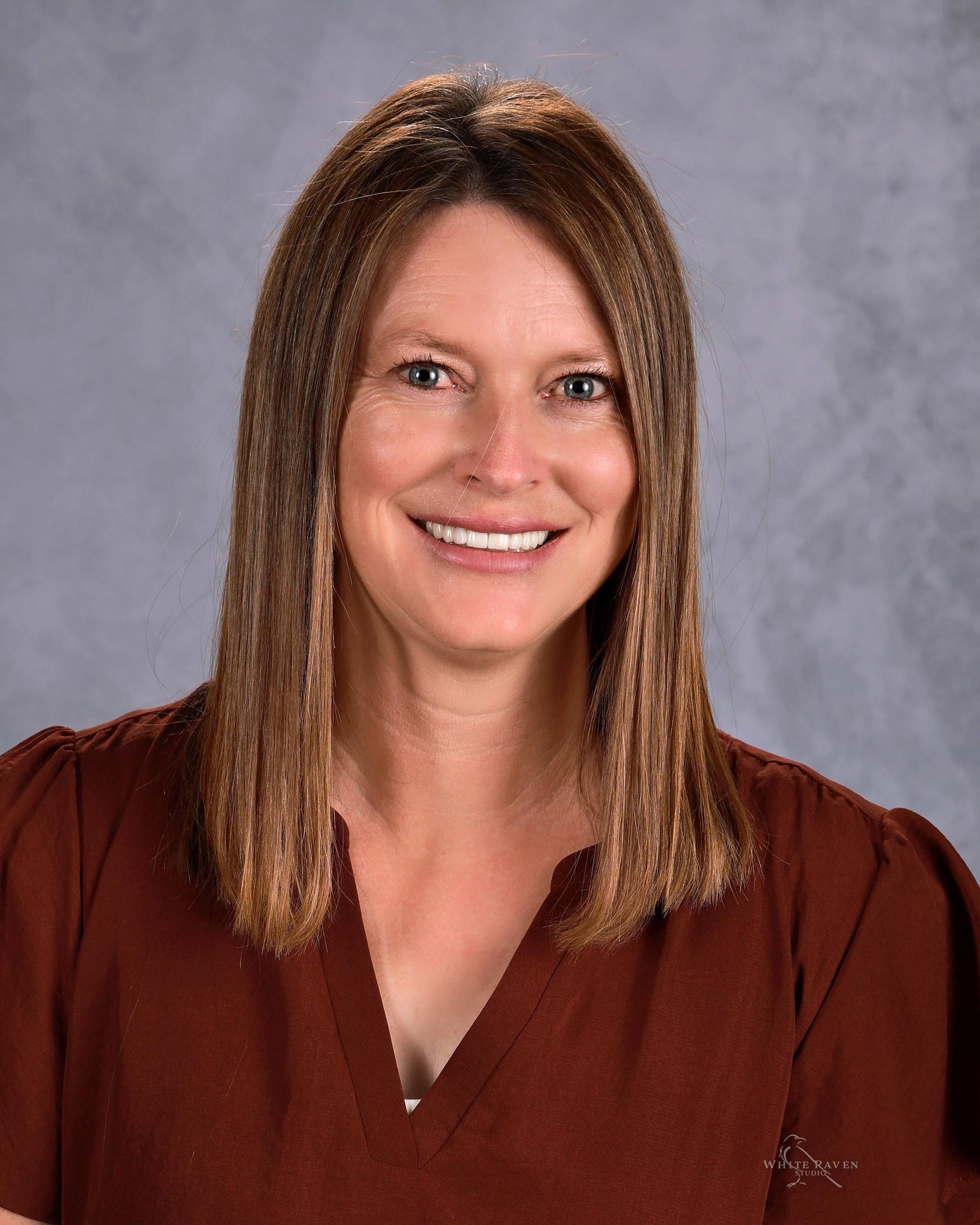 Woman in flowered shirt smiling at camera