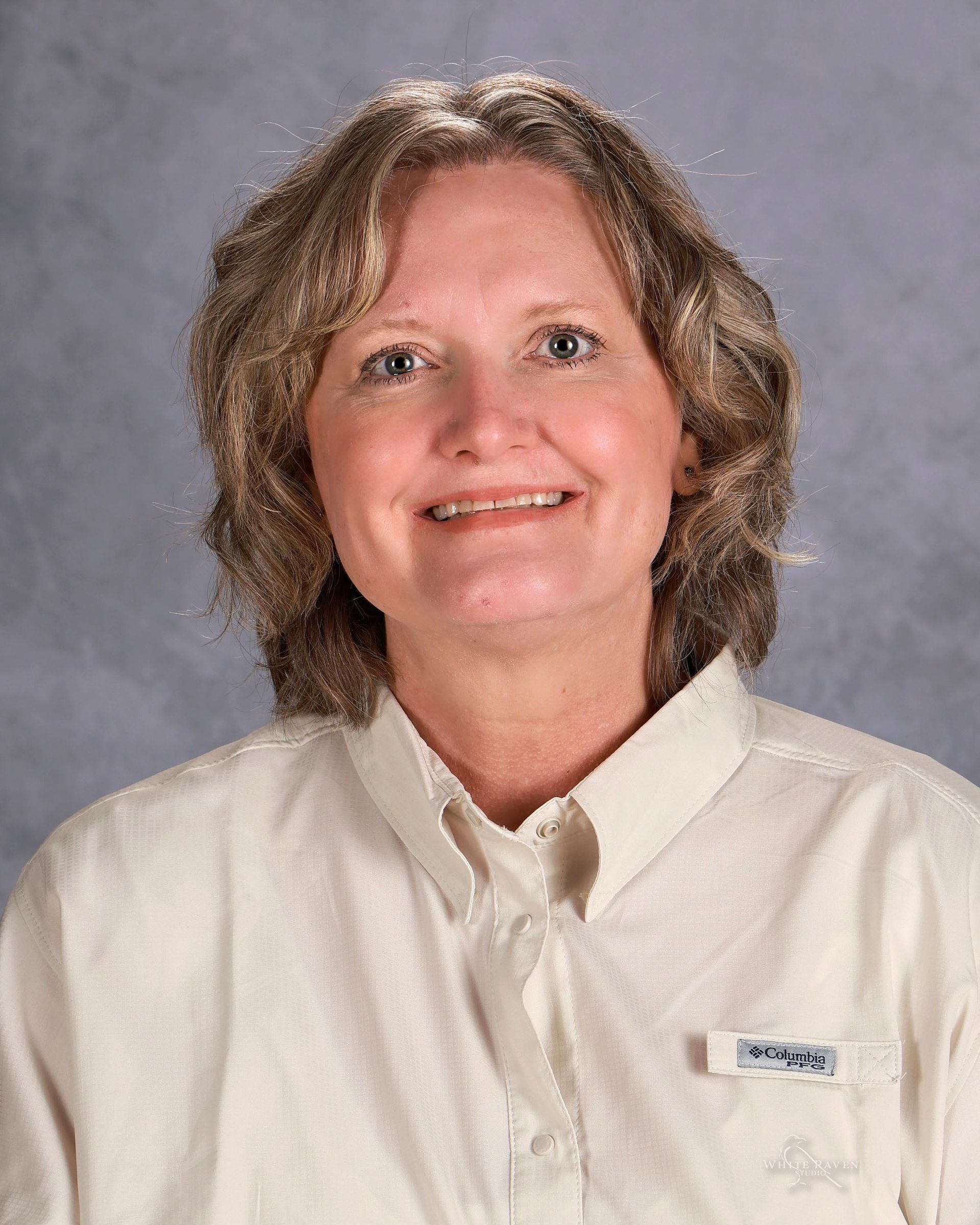 Woman in green shirt smiling for camera