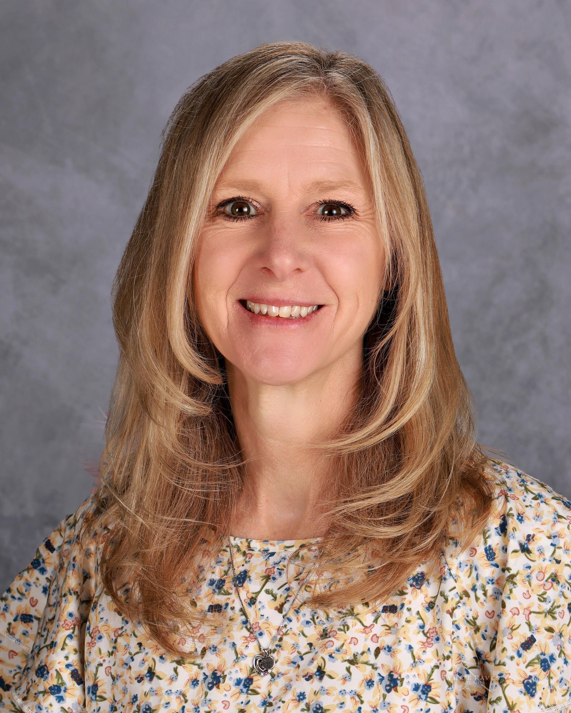 Woman in blue shirt smiling at camera