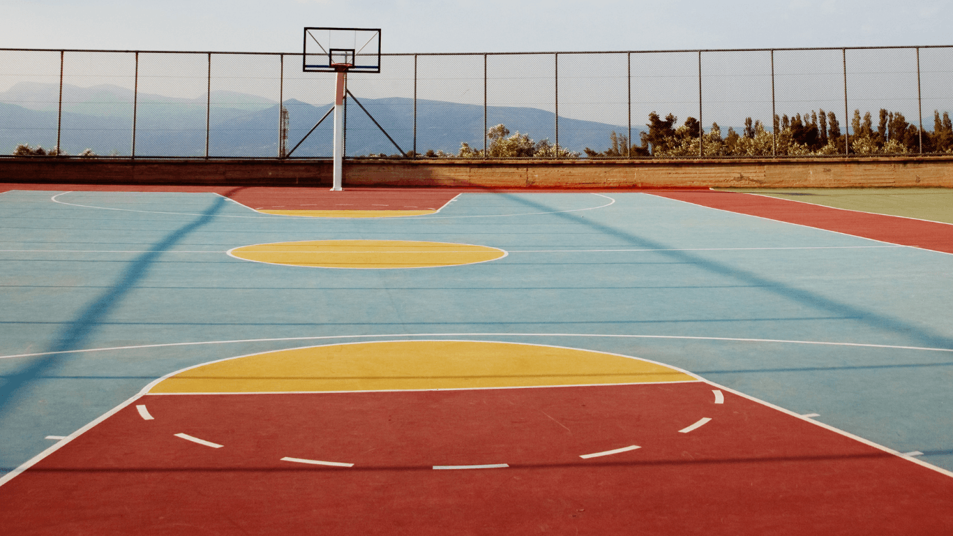 Bright outdoor basketball court with colorful painted sections and clean boundary lines after a court installation service in Peoria, AZ