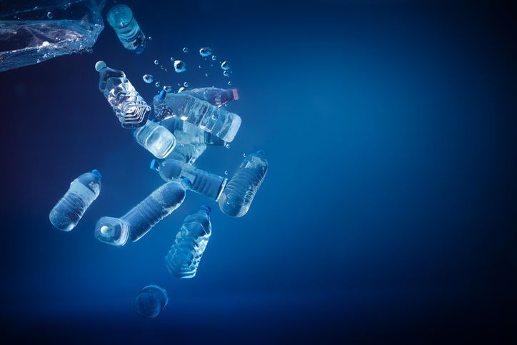 A bunch of plastic bottles are floating in the ocean.