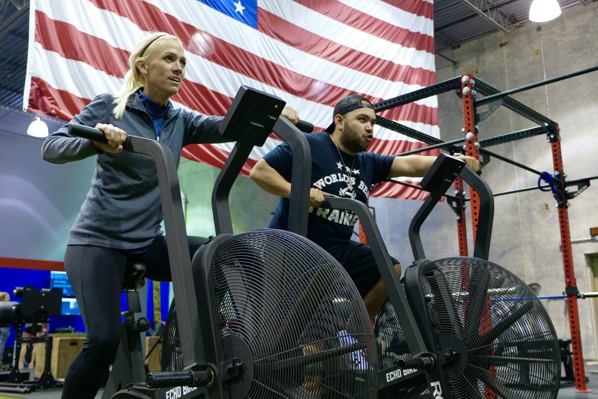 blond woman and man with hat working out on stationary bikes