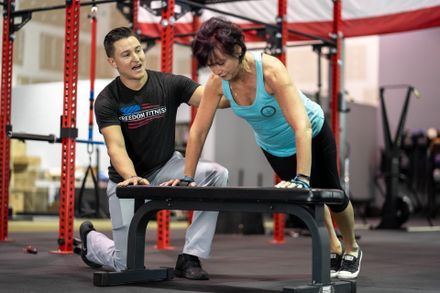 women doing push ups with a personal trainer