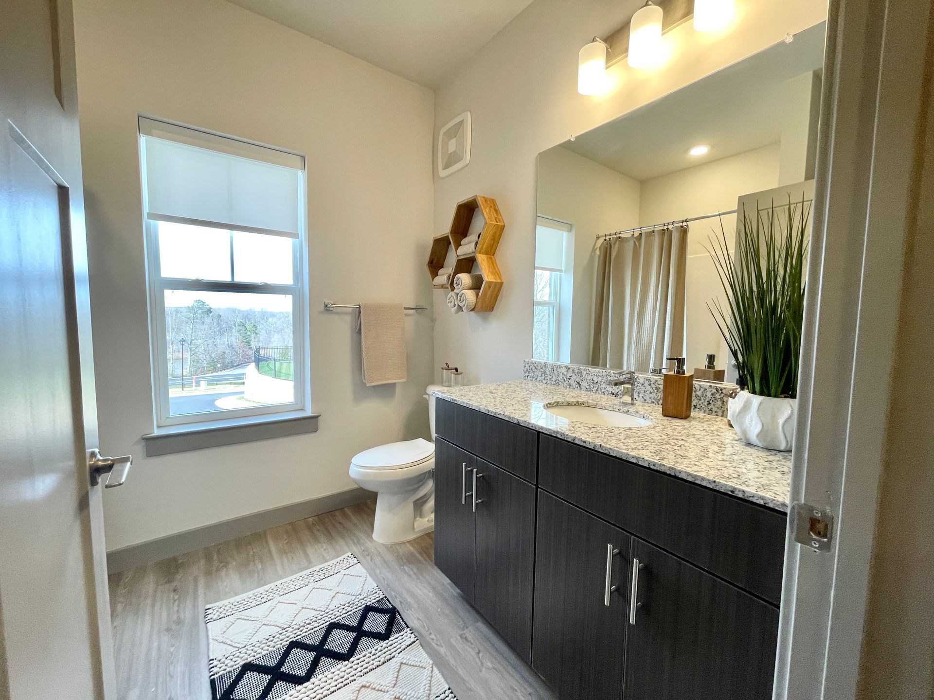 A bathroom with a toilet , sink , and mirror.