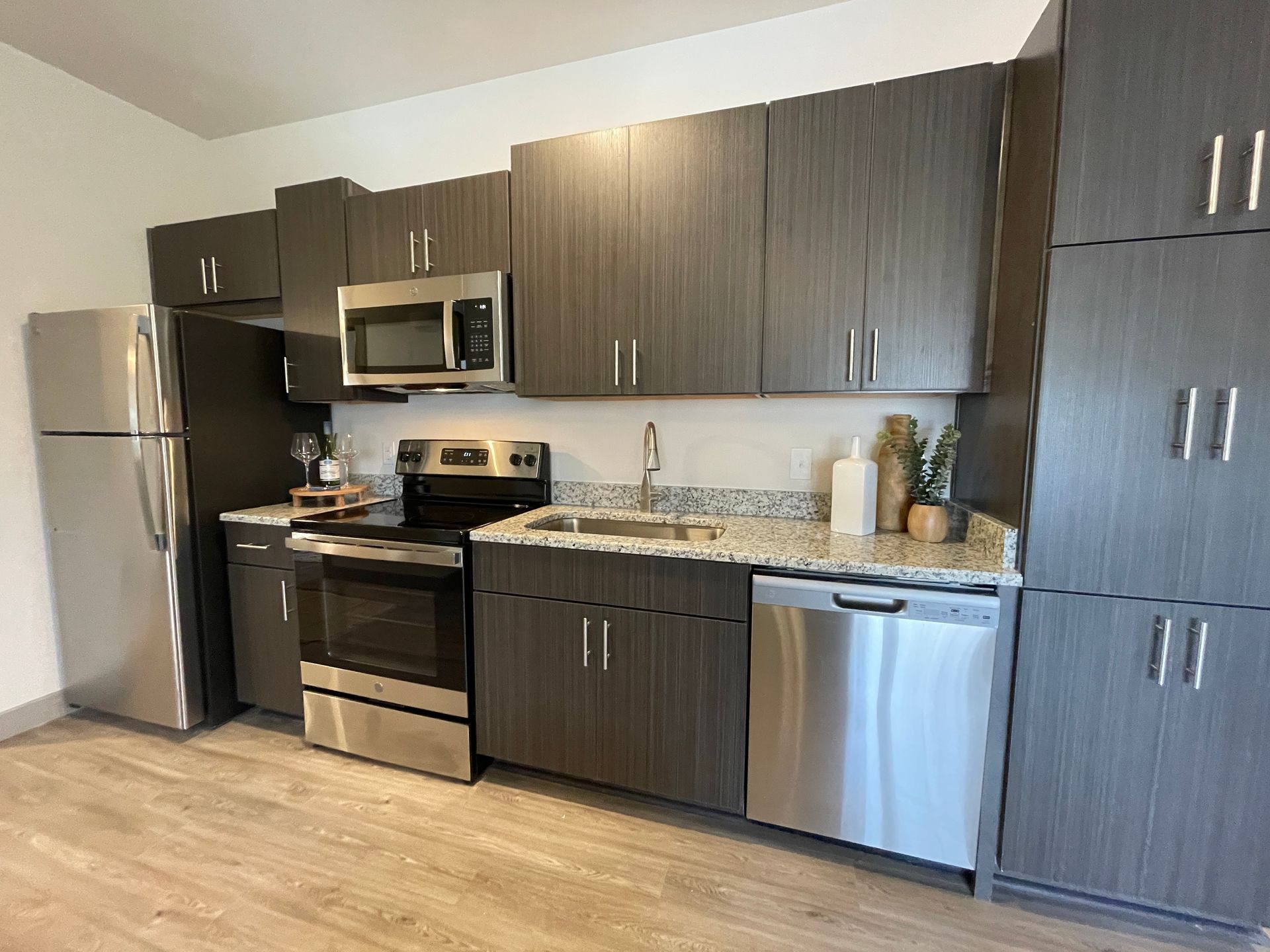 A kitchen with stainless steel appliances and wooden cabinets.