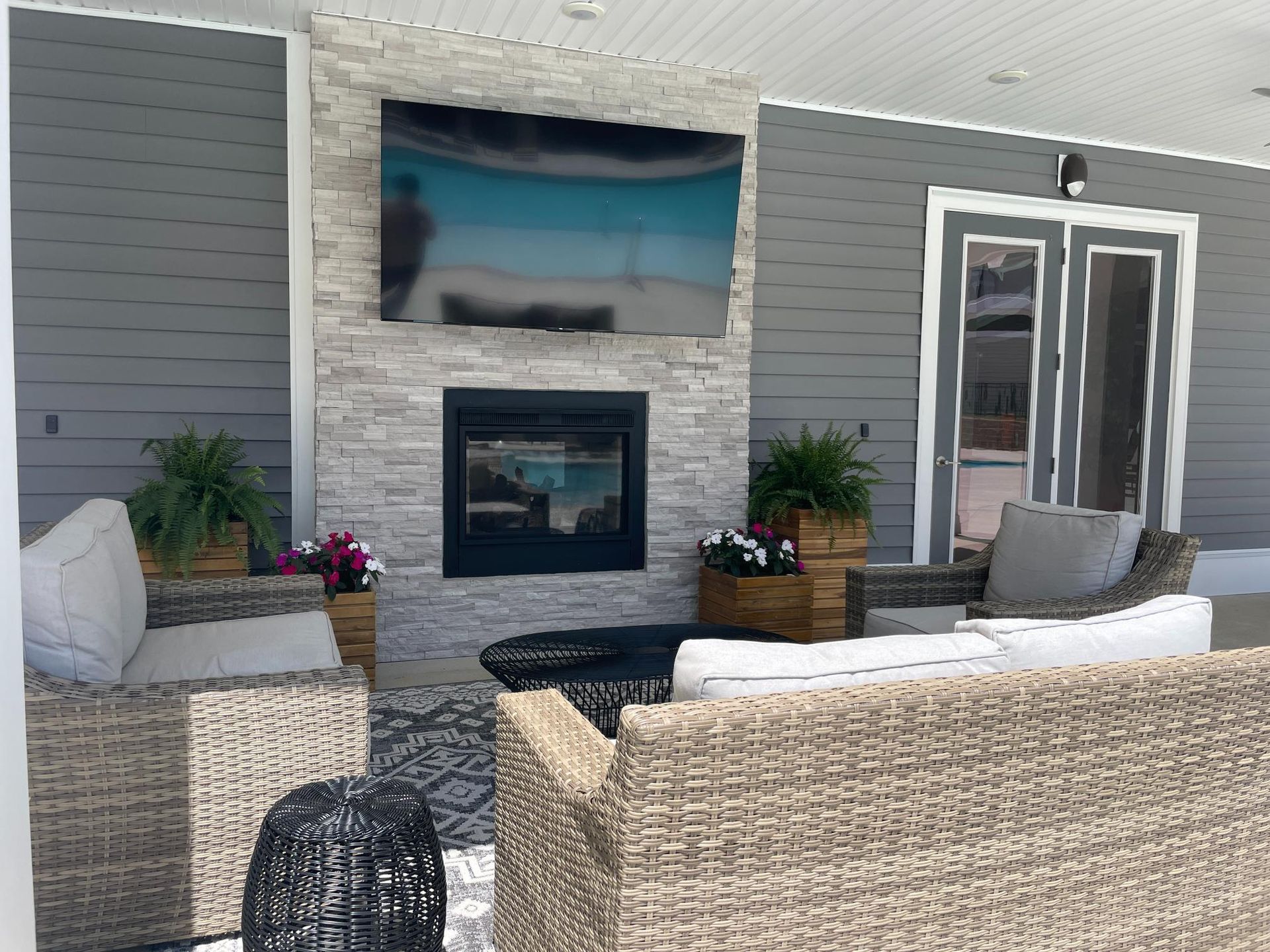 A living room with a fireplace and a flat screen tv on the wall.