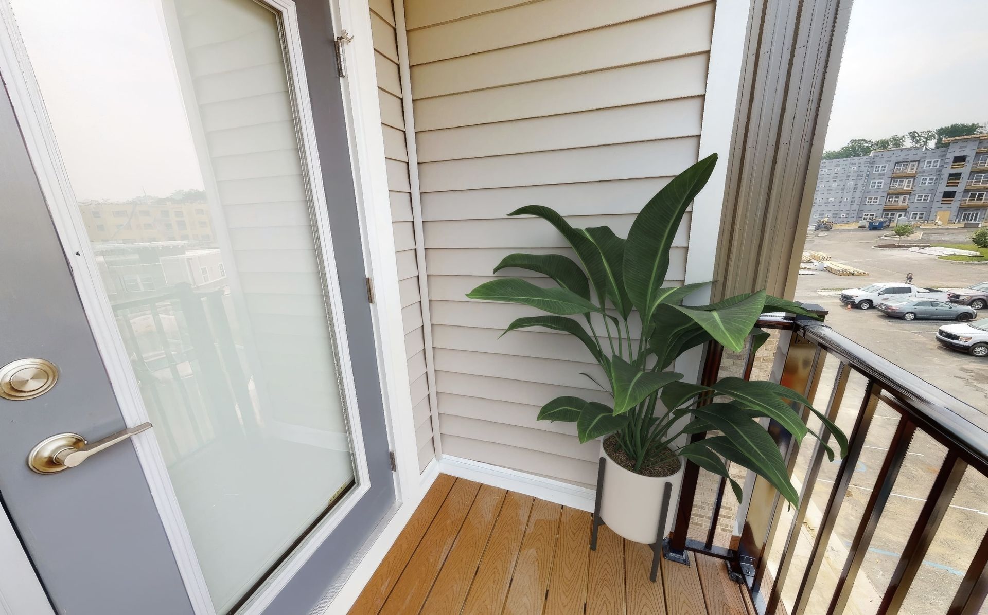 A balcony with a potted plant and a sliding glass door.