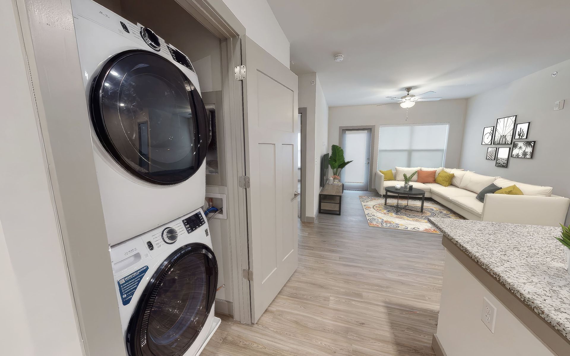 A washer and dryer are stacked on top of each other in a living room.