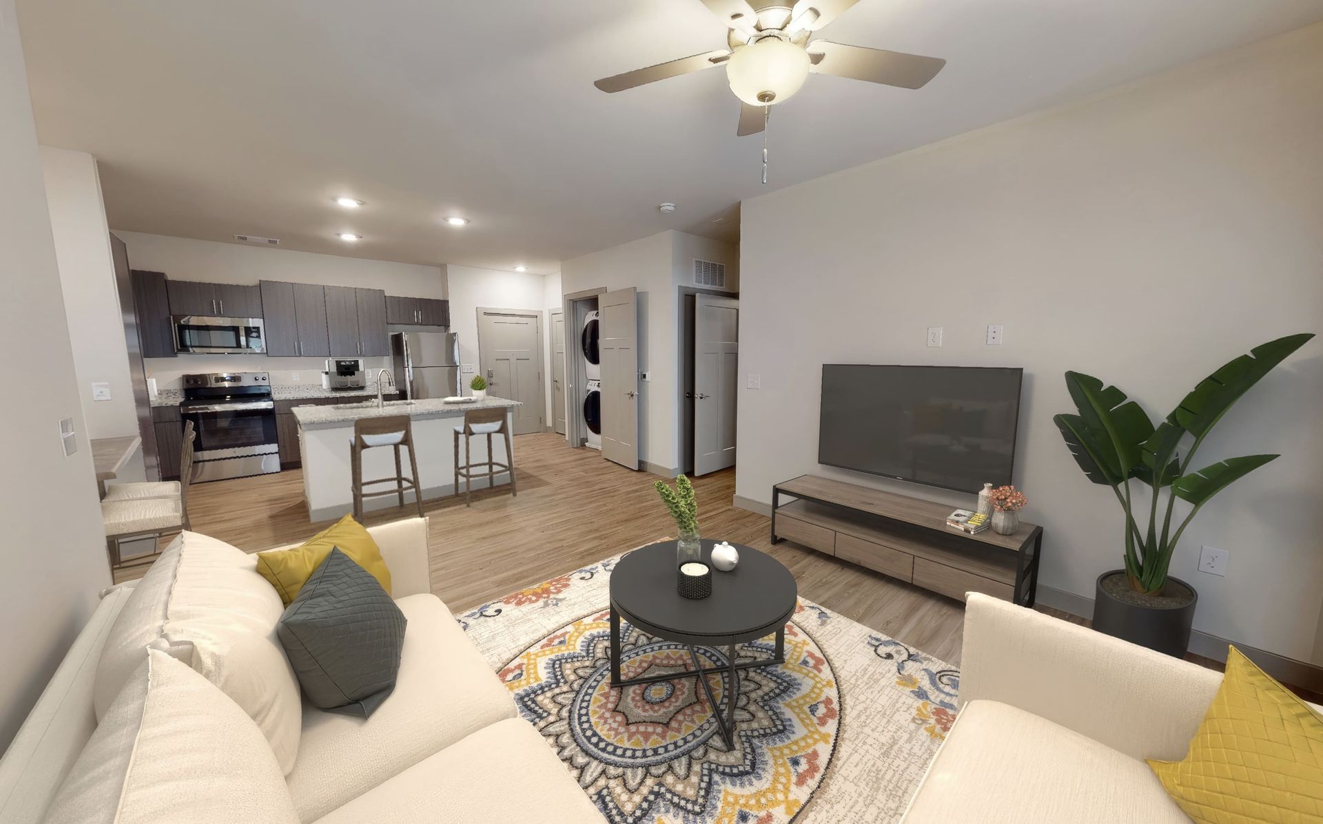 A living room with a couch , table , television and ceiling fan.