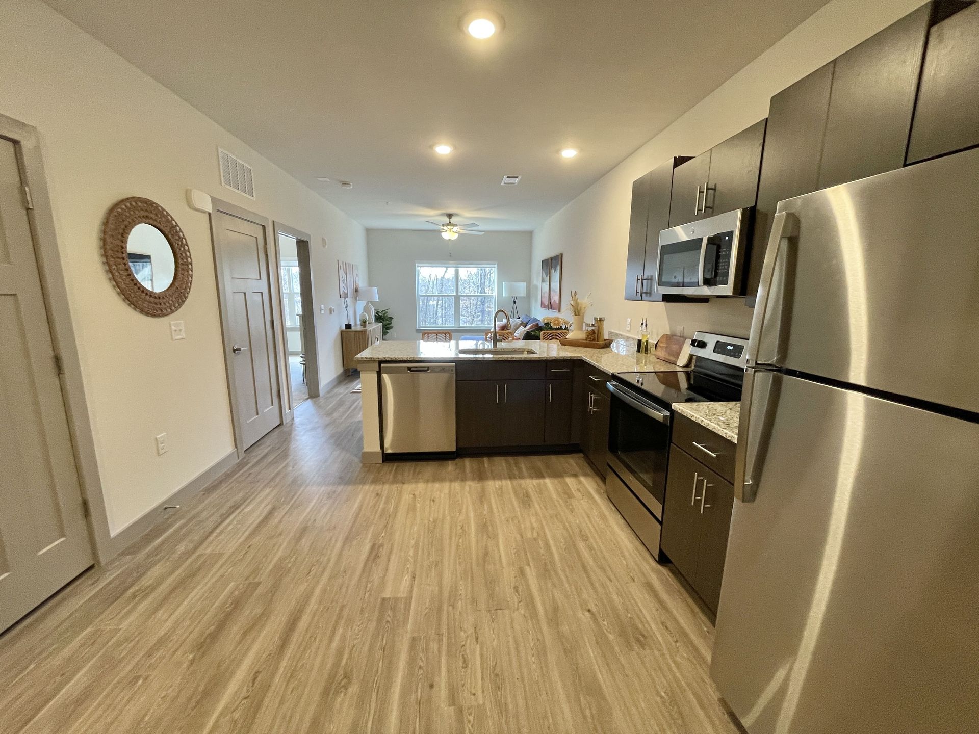 A kitchen with stainless steel appliances and wooden floors.