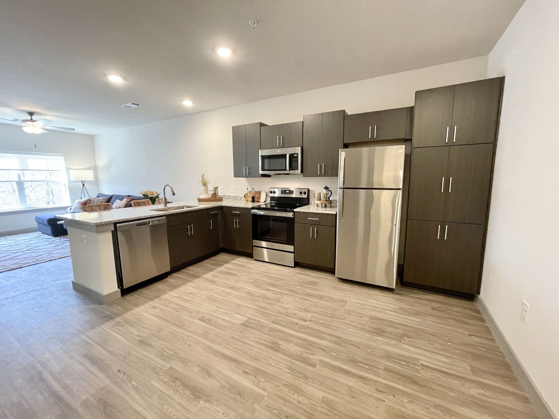 A kitchen with stainless steel appliances and wooden floors.