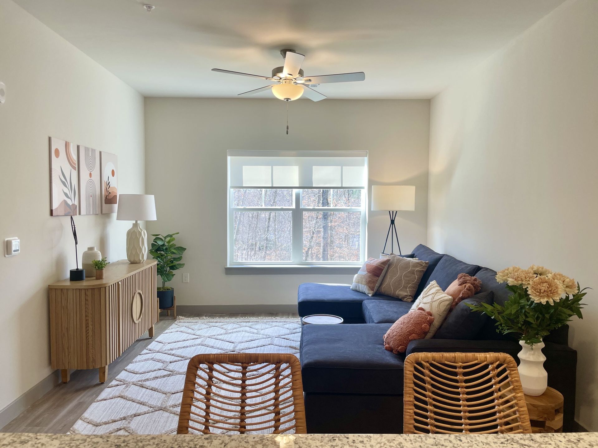 A living room with a blue couch and a ceiling fan