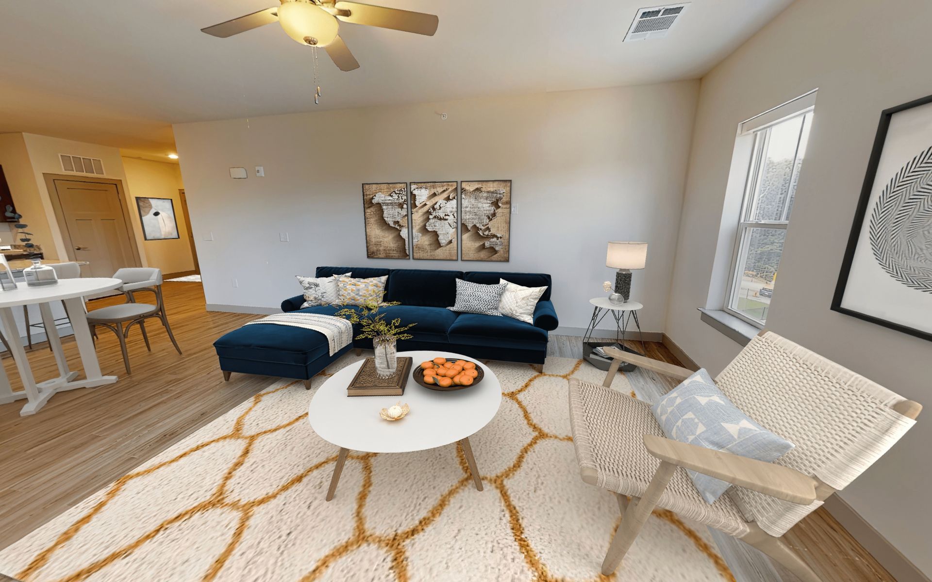 A living room with a couch , chair , coffee table and ceiling fan.