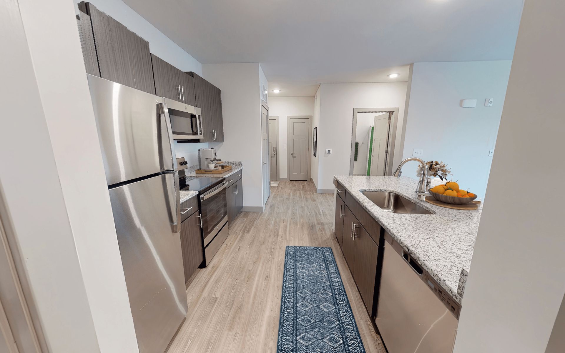 A kitchen with stainless steel appliances and granite counter tops.