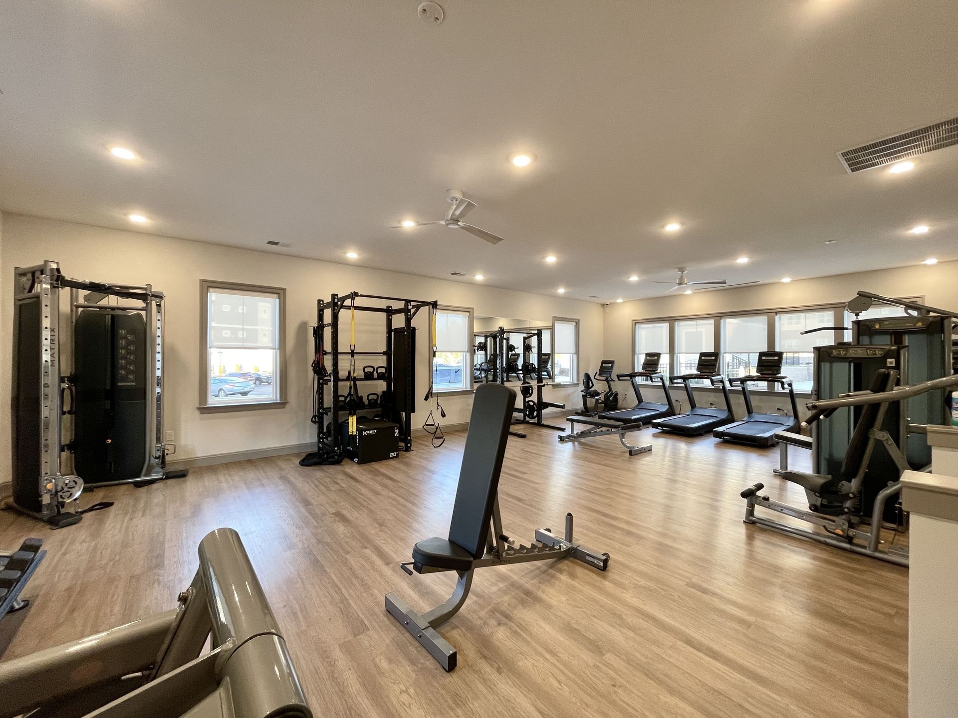 A large gym with a lot of equipment and a bench.