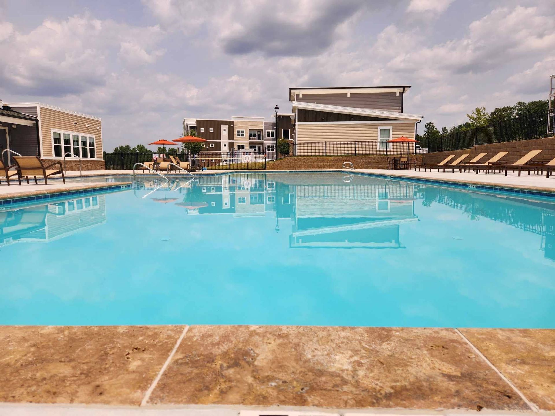 A large swimming pool with a building in the background.