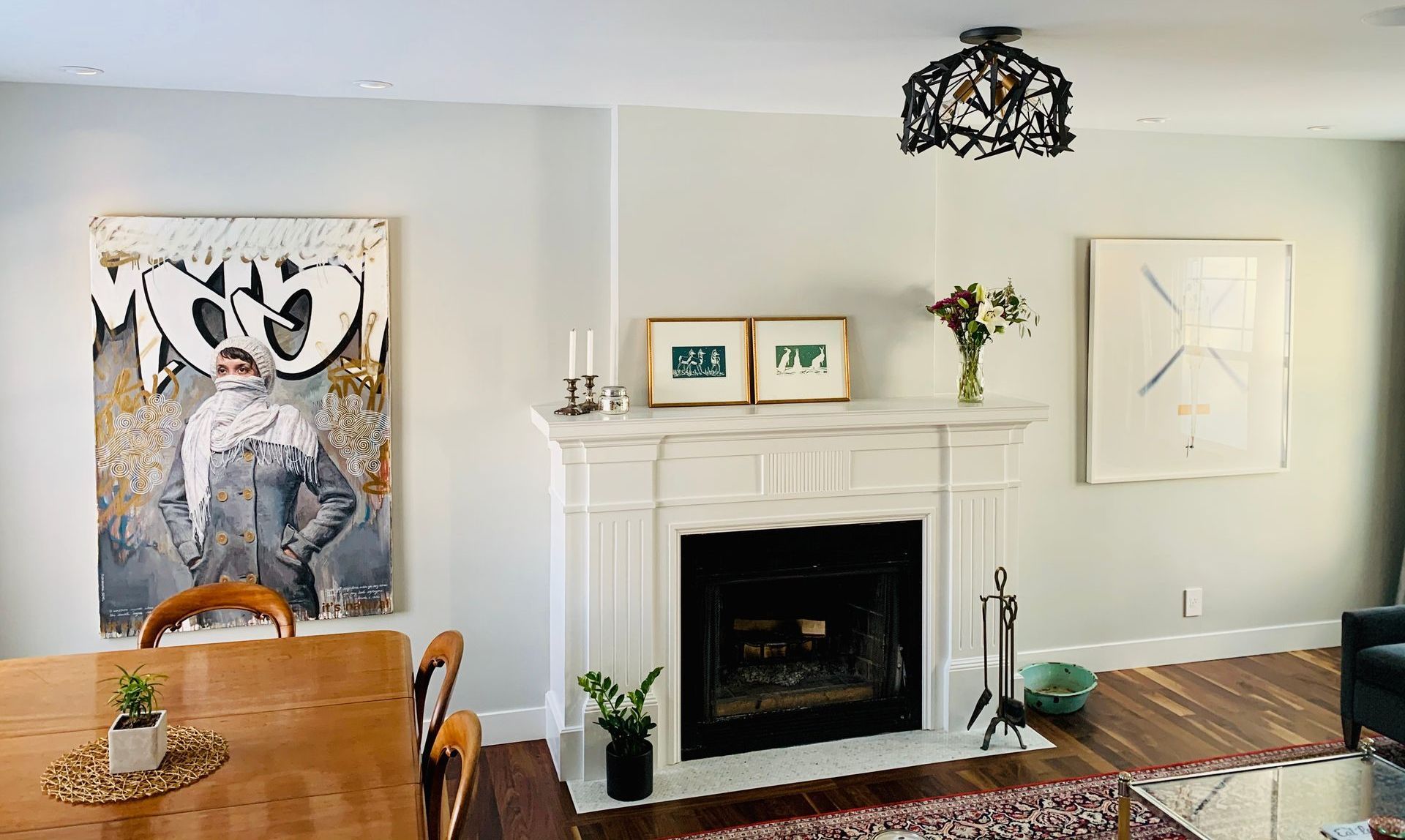 A living room with a fireplace and a painting on the wall.