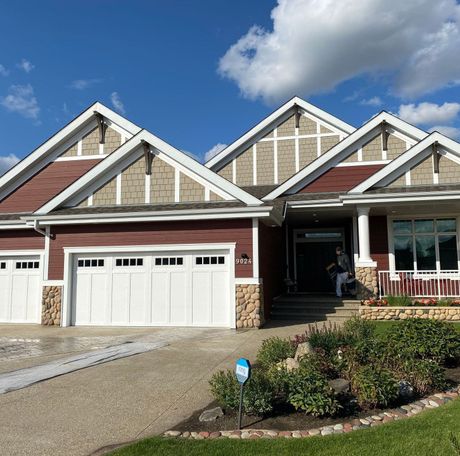 A large house with a lot of windows and garage doors