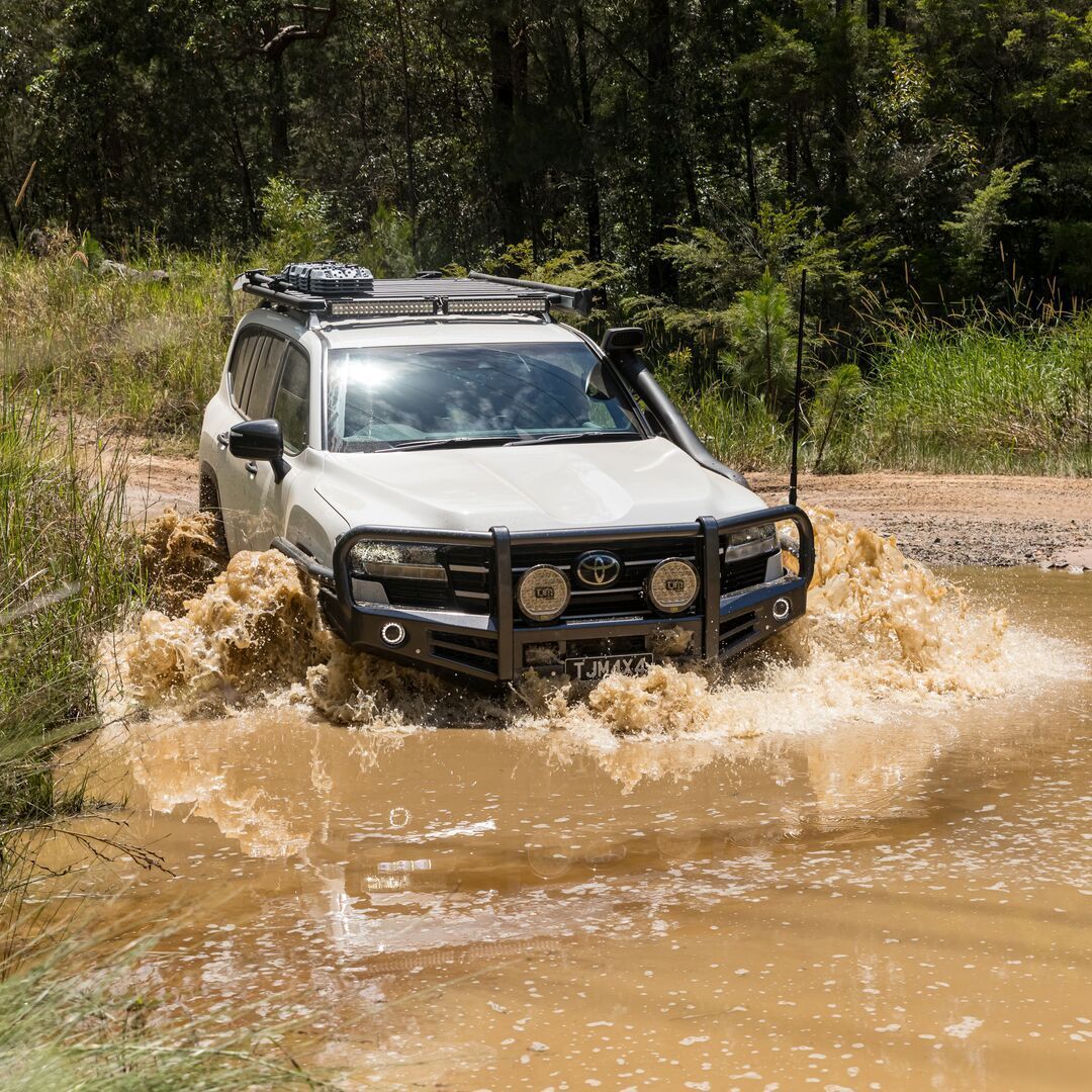 White SUV Fording a Muddy Creek in a Forest — TJM Wagga Wagga In Ashmont, NSW