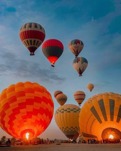 hot air balloons inflating and taking off at sunrise in Luxor, Egypt
