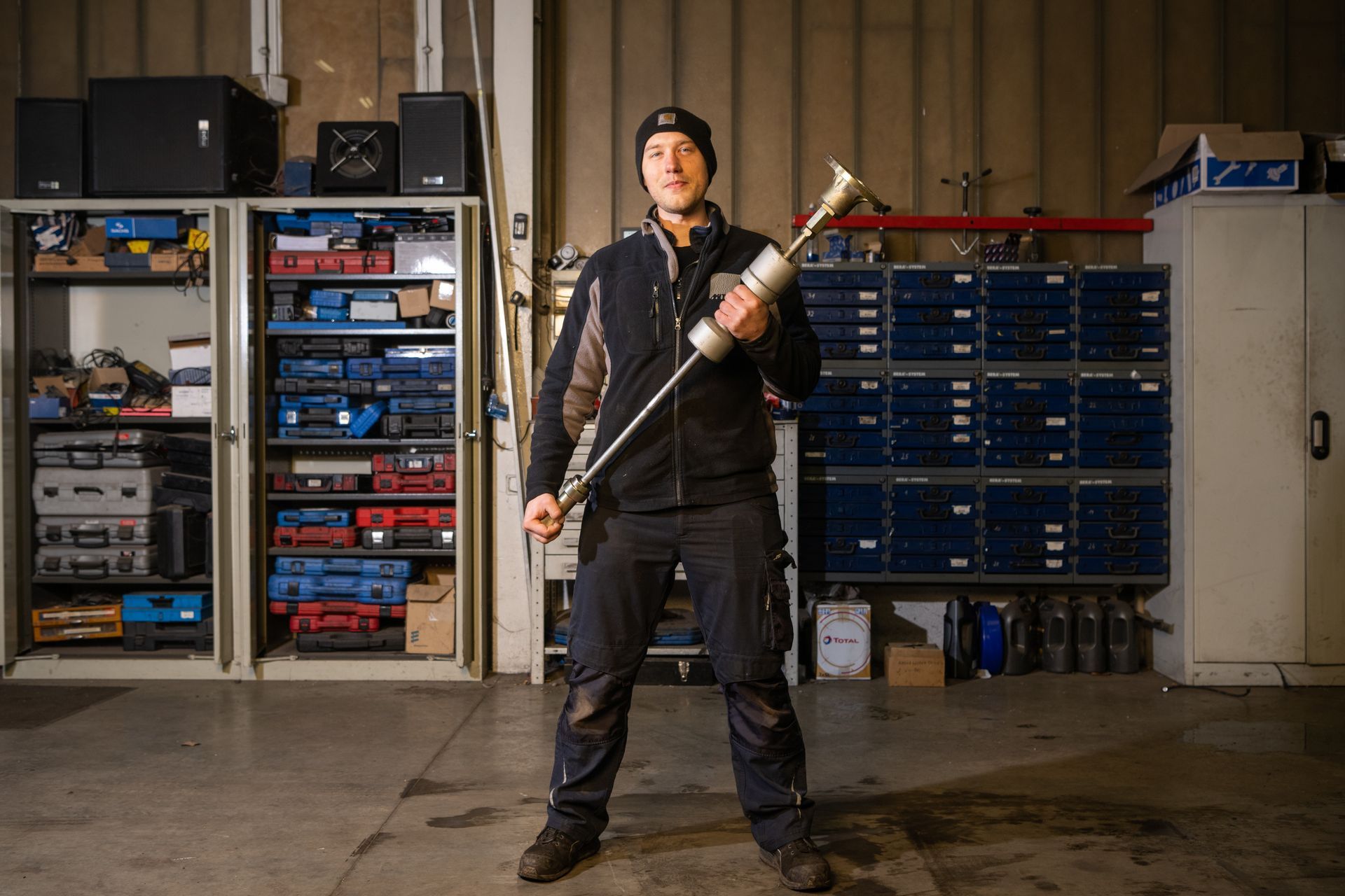 Automechaniker hält ein Werkzeug in der Hand