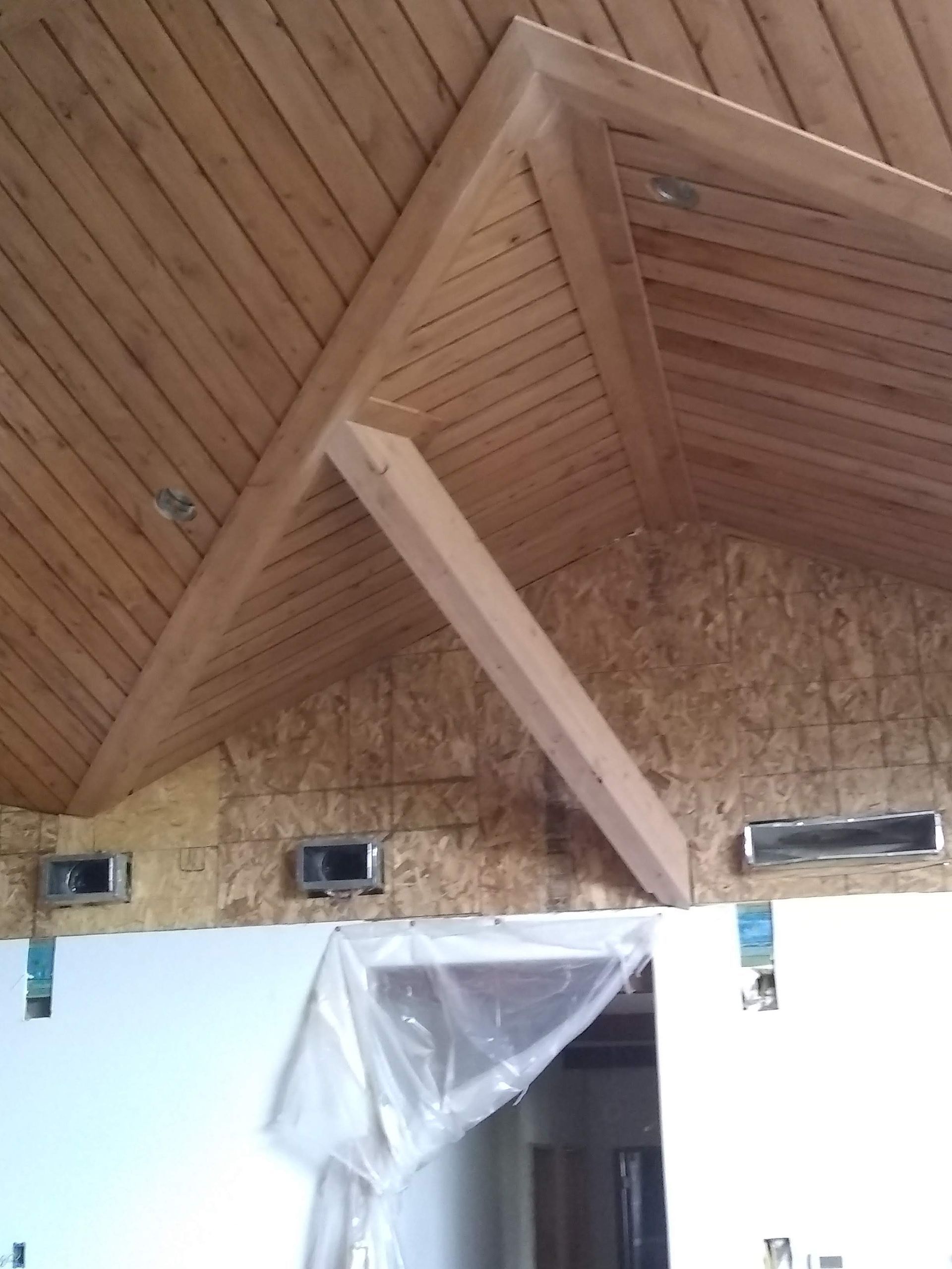 A room with a wooden ceiling and a white door