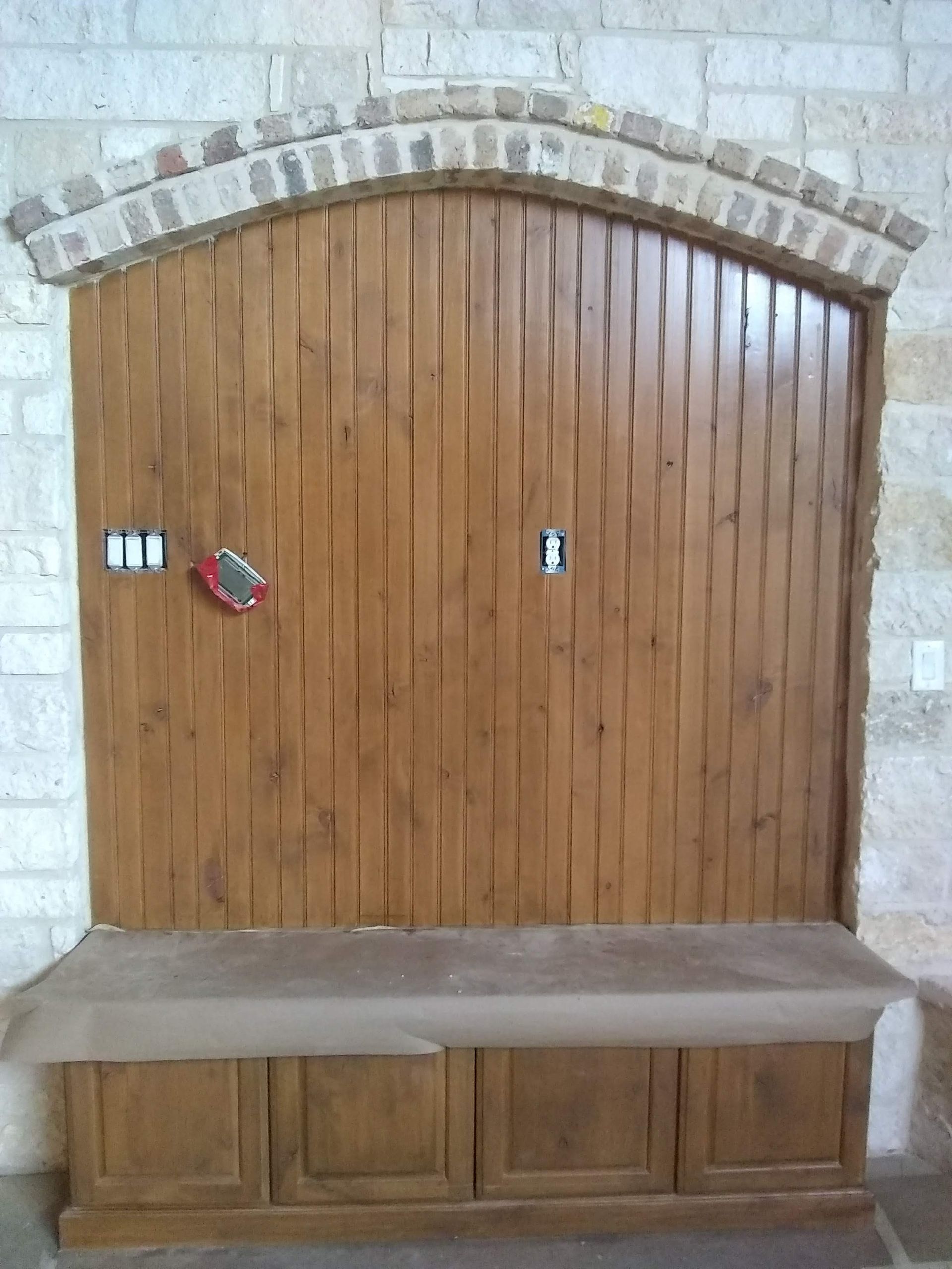 A wooden wall with a bench underneath it