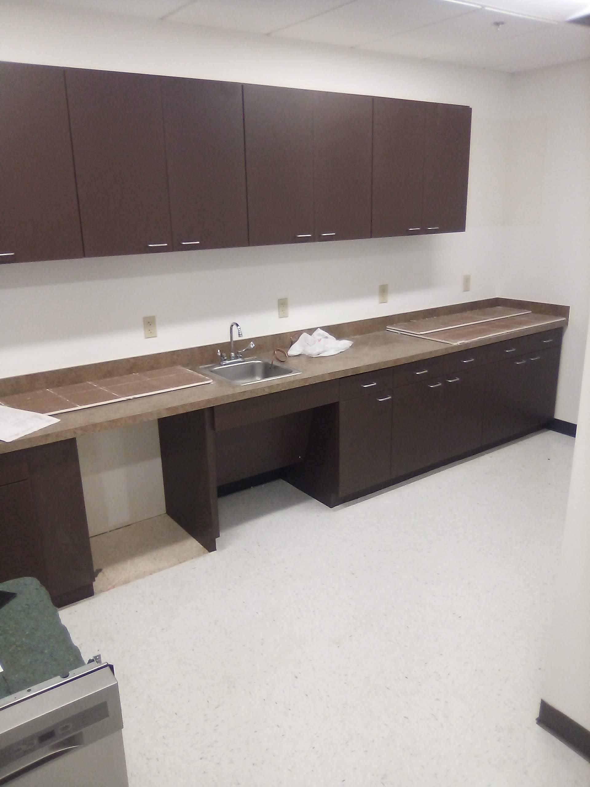 A kitchen with brown cabinets and a sink