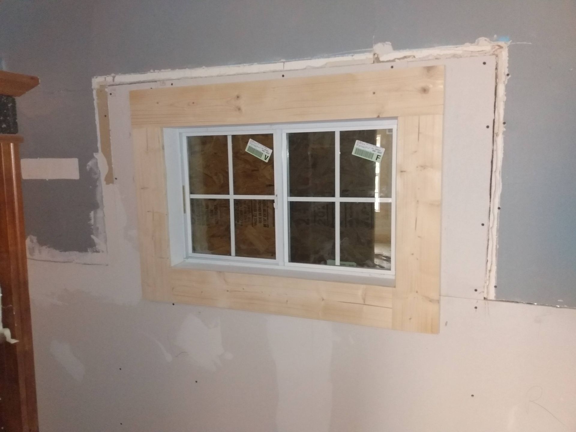 A window is being built into a wall in a room.