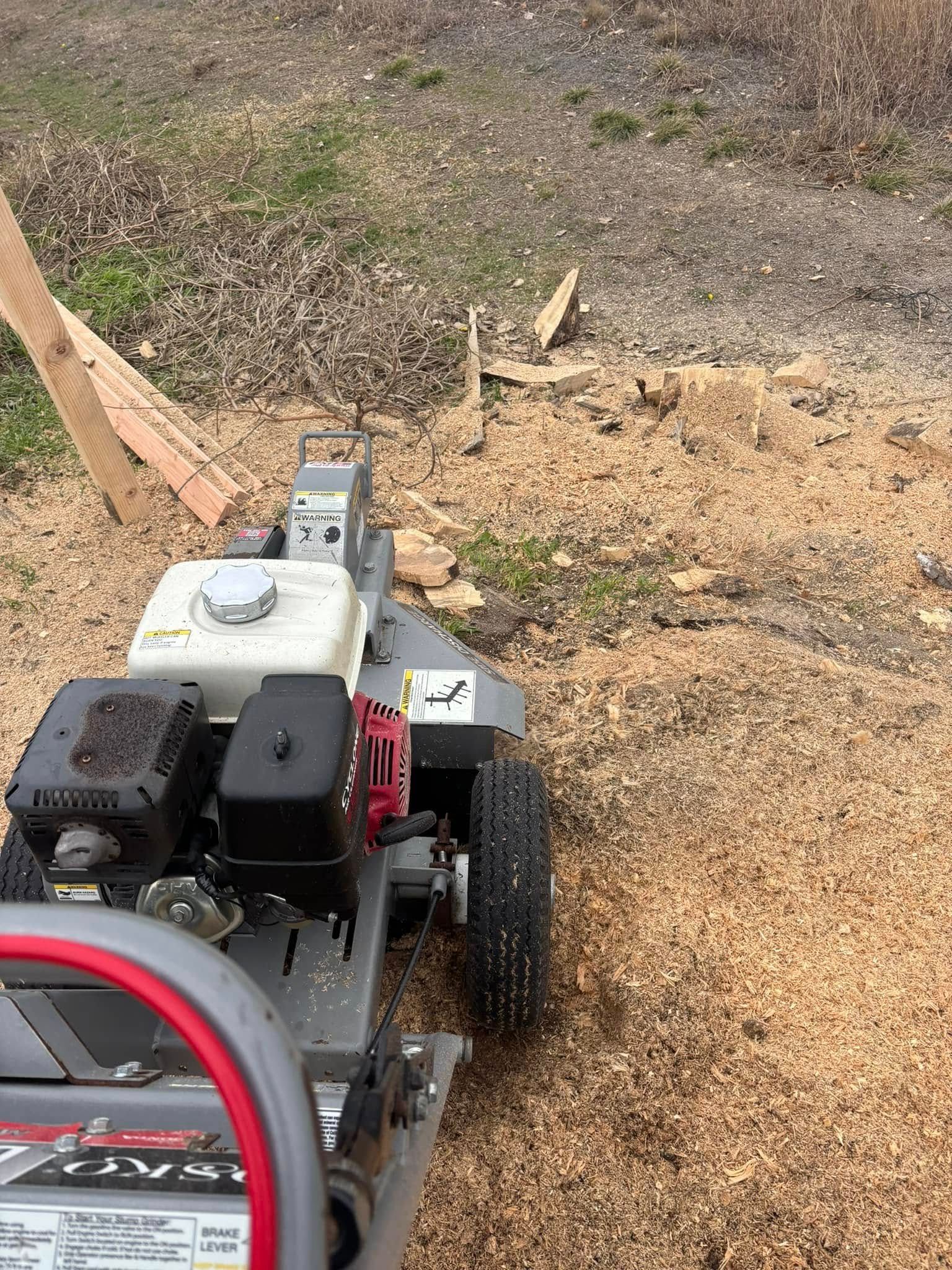 A stump grinder is sitting on top of a pile of wood chips.