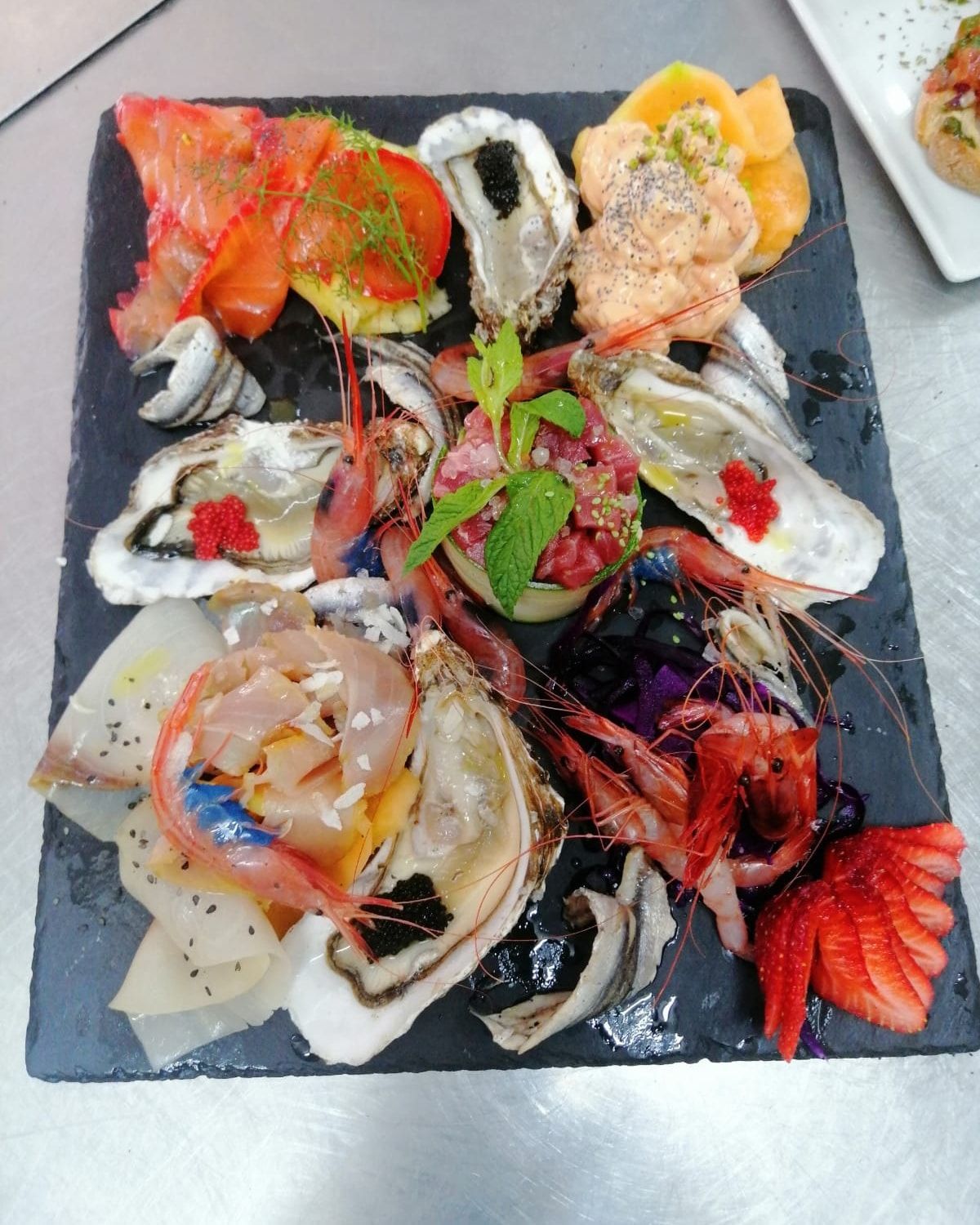 Un piatto di frutti di mare con gamberi e ostriche