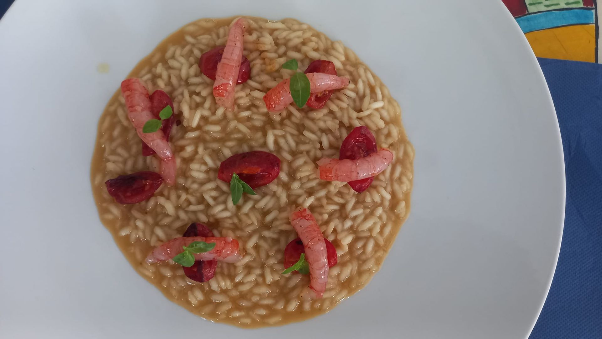 Un piatto bianco con riso e gamberi su un tavolo