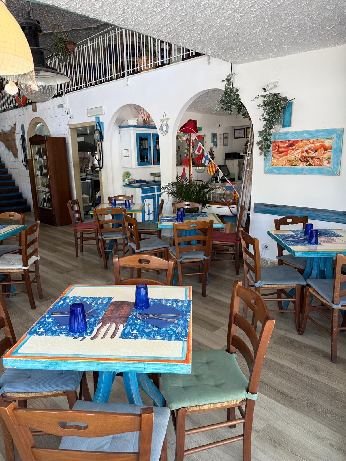 Un ristorante pieno di tavoli e sedie con vetri blu.