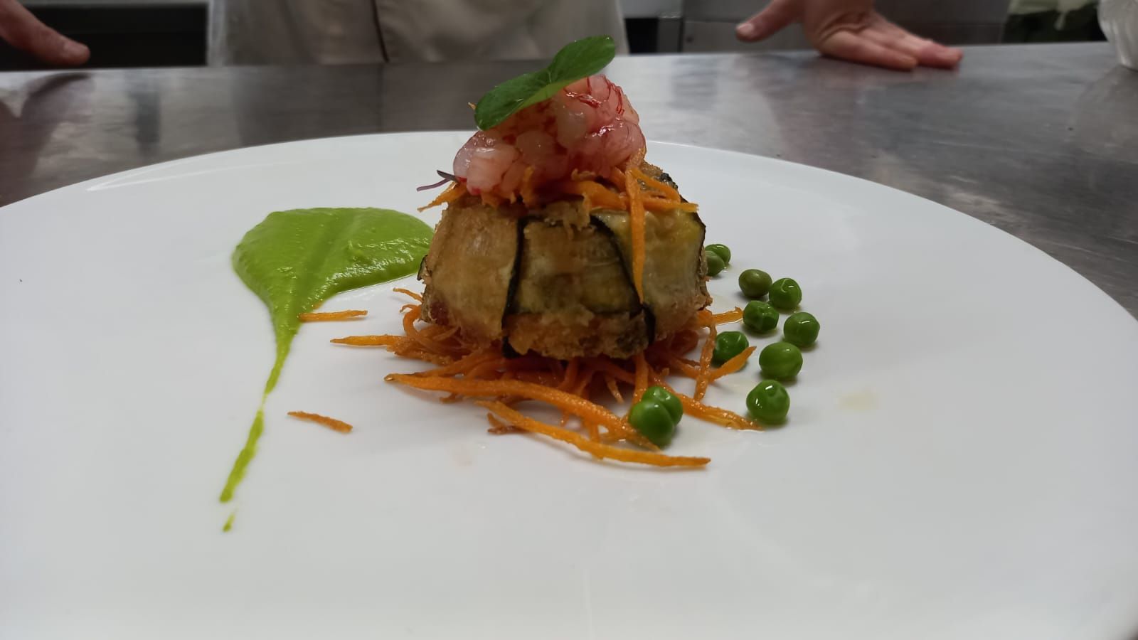 Un piatto bianco con verdure e gamberetti su un tavolo.